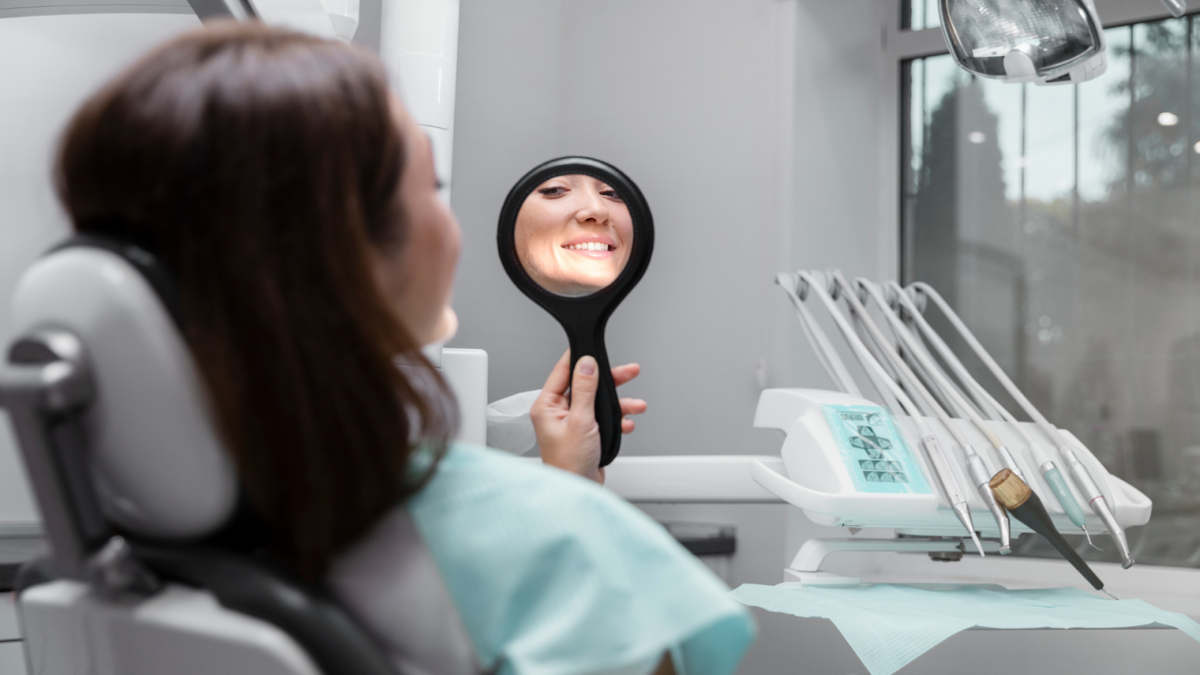 A woman admiring her smile after getting teeth whitening treatment